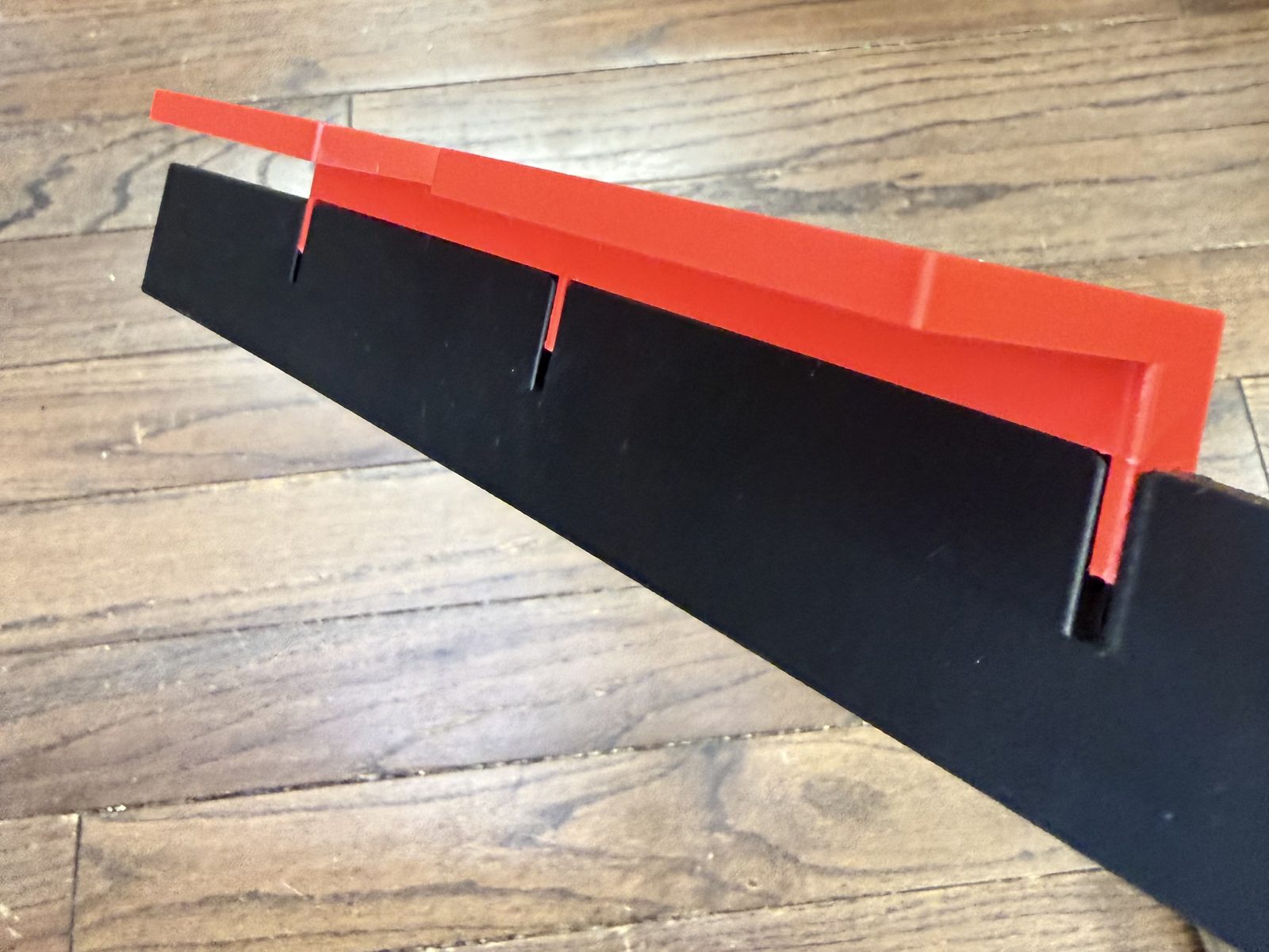 Red AMS 2 Pro template with its three arms slotted into the three narrow slots of a black four-post holder