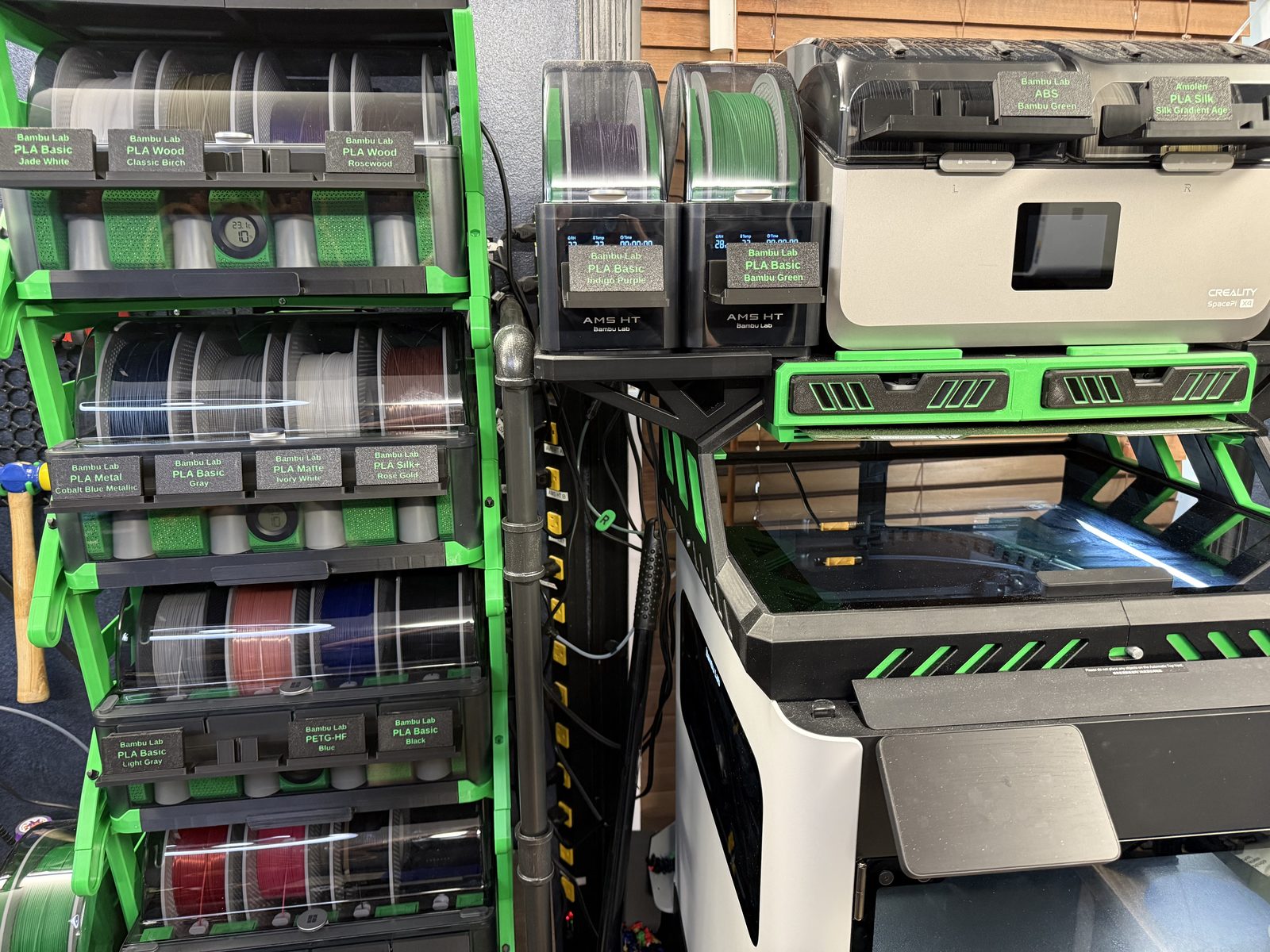 Label clips in holders on the front of AMS units and a Creality SpacePi X4 dryer